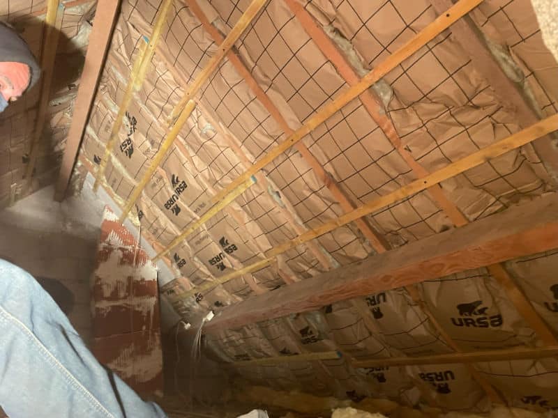 Gros plan sur des ouvriers en train d'installer une isolation à l'intérieur de comble aménagé dans une toiture dans le Nord